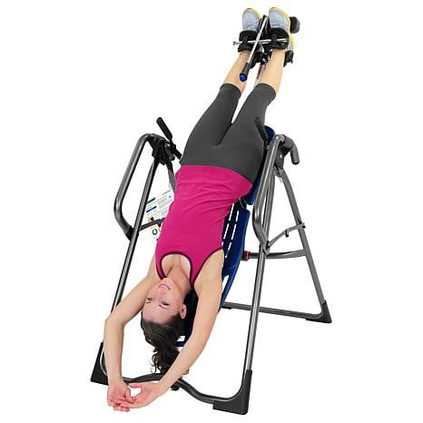 A woman stretching on an inversion table.